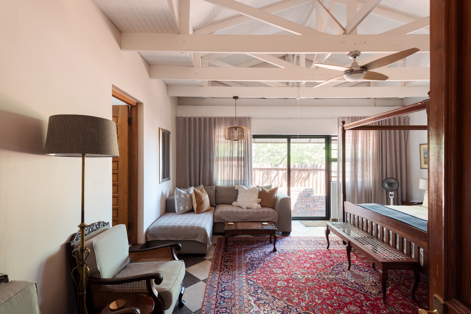 Guest suite lounge with four-poster bed and antique bench