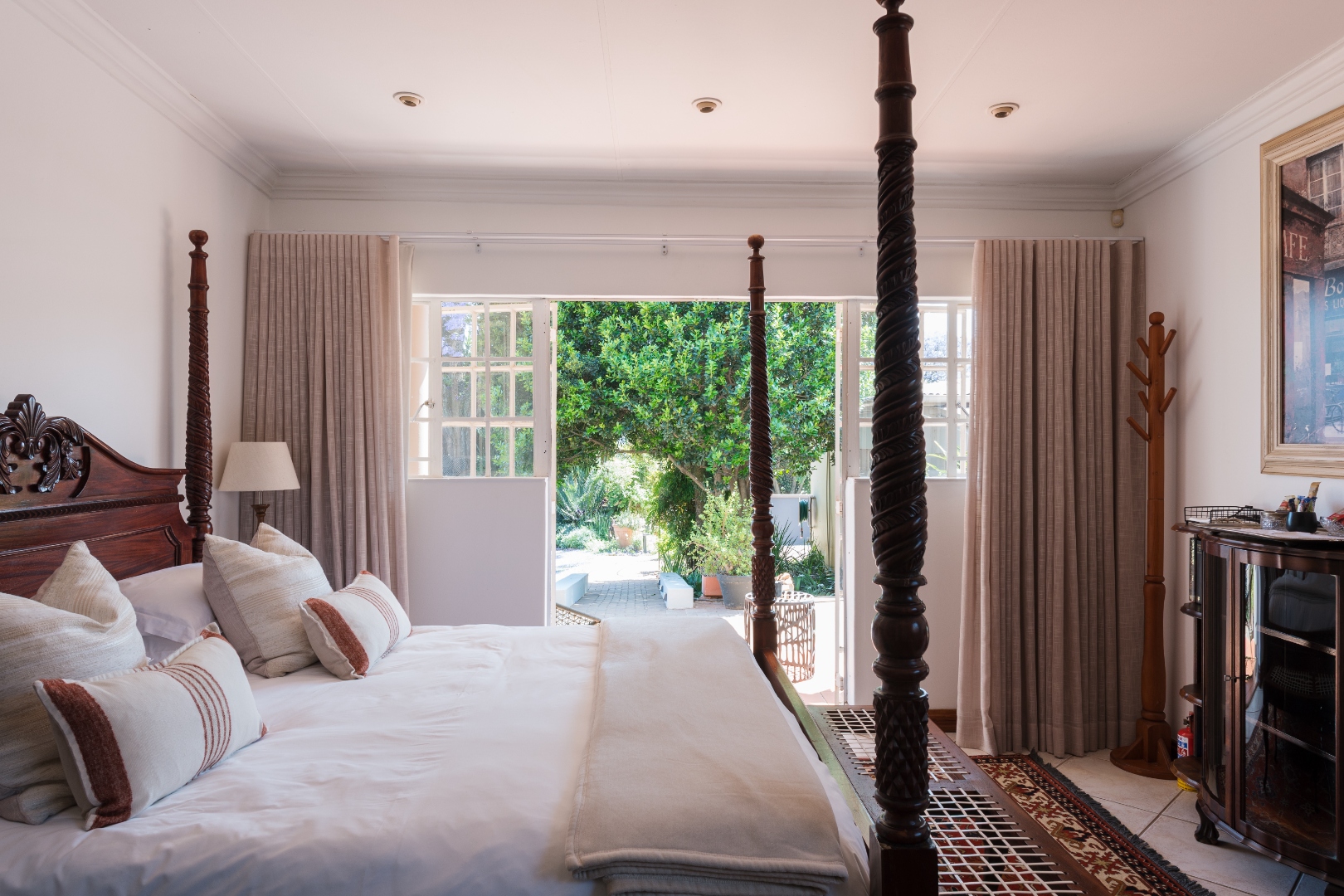 Luxury King Room with four-poster bed opening onto the garden at House Falcon Guest House